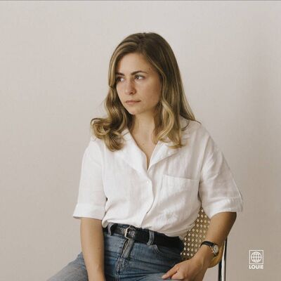 Yana zit op een stoel en kijkt schuin in de verte.